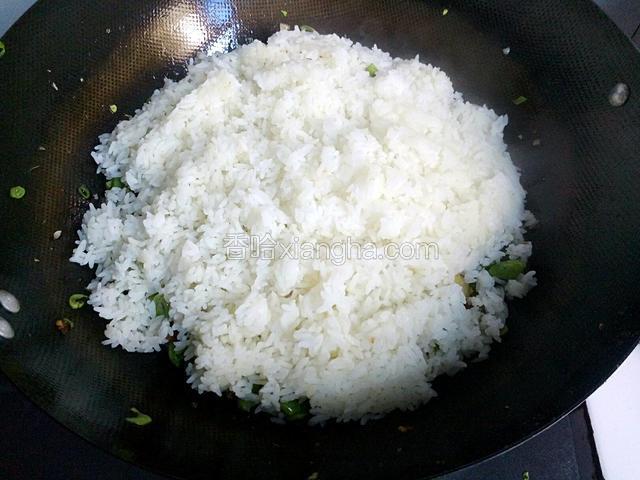 在把沥好的米倒入炒好的豆角上面，在转小火慢慢焖