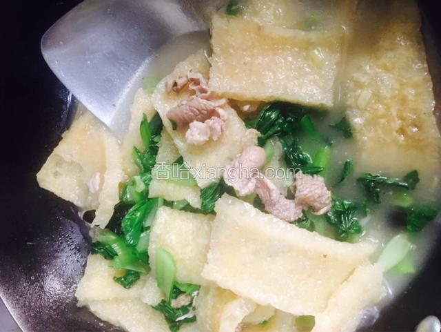 放入青菜和适量的盐、白糖和胡椒粉继续炖煮。