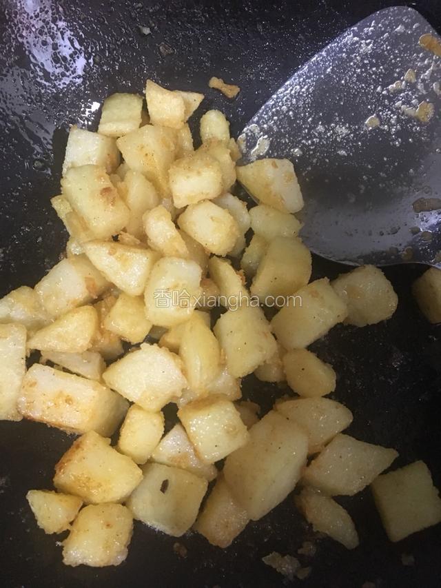 一直煎到外皮焦黄香脆，放入少许辣椒粉、少许花椒粉和少许盐，翻炒均匀。
