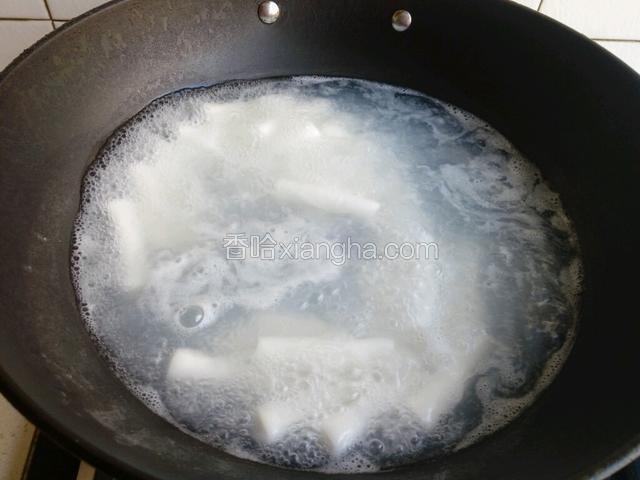 锅中水开后，下入年糕。煮至变软盛出备用。