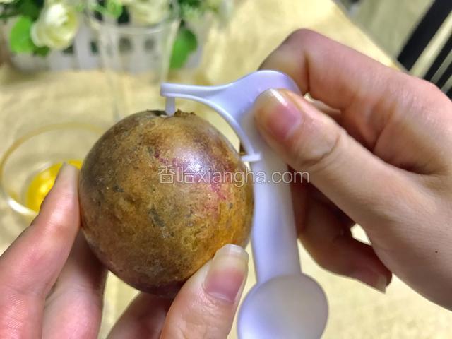 用百香果开启器带尖的一头，插入百香果上，顺时用点力划一圈