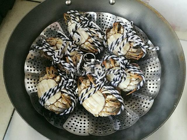 刷干净的螃蟹用绳子在捆起来，放入锅中，大火蒸20分钟，关火后虚蒸2分钟即可