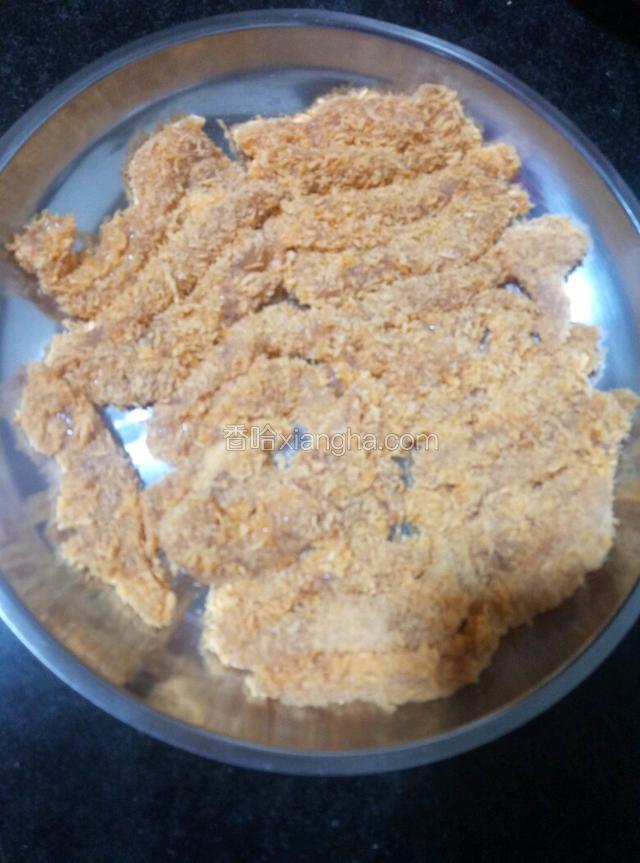 把裹了鸡蛋和芡粉的鸡胸肉再放到面包糠里裹一层，全裹好了再放进油锅里炸