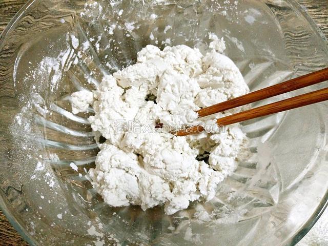 糯米粉放在大容器中，边倒水边用筷子搅拌，无干粉状即可