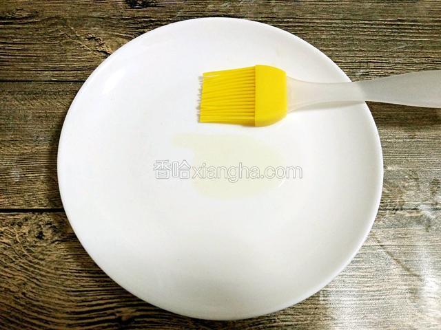 放少量玉米油在盘中，用刷子刷均匀
