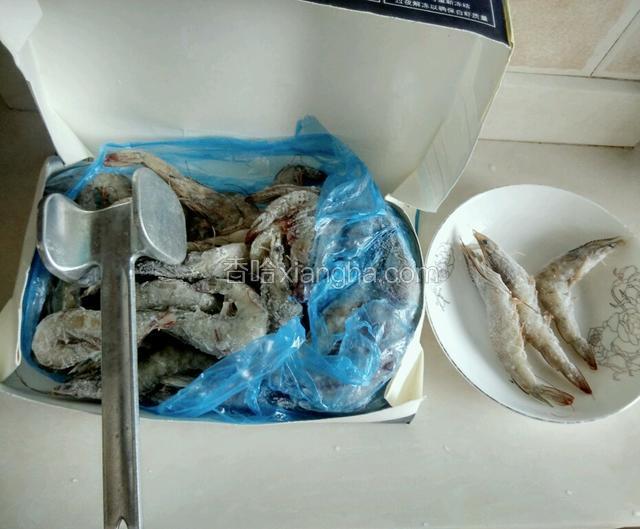 从冰箱取出冷冻虾盒，用松肉槌敲松冻结在一起的虾，取你所需的虾。