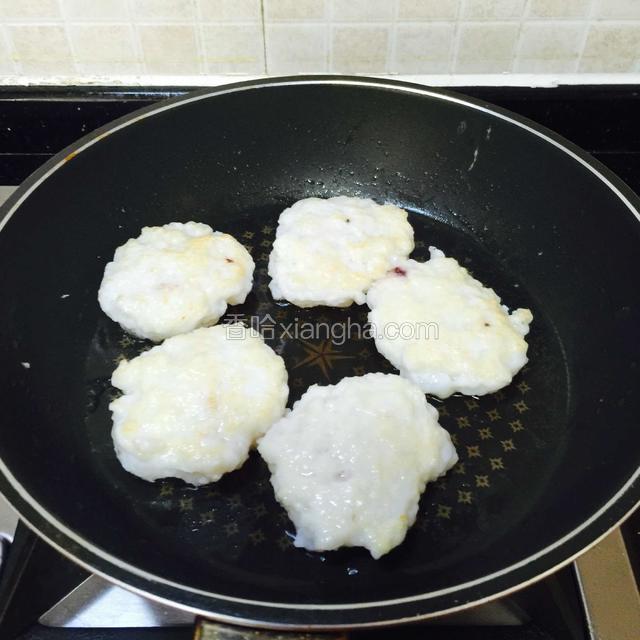 煎至一面凝固，翻面煎另一面。
中小火煎。
中途可以多次翻面，受热才均匀，墨鱼饼才会熟透。
