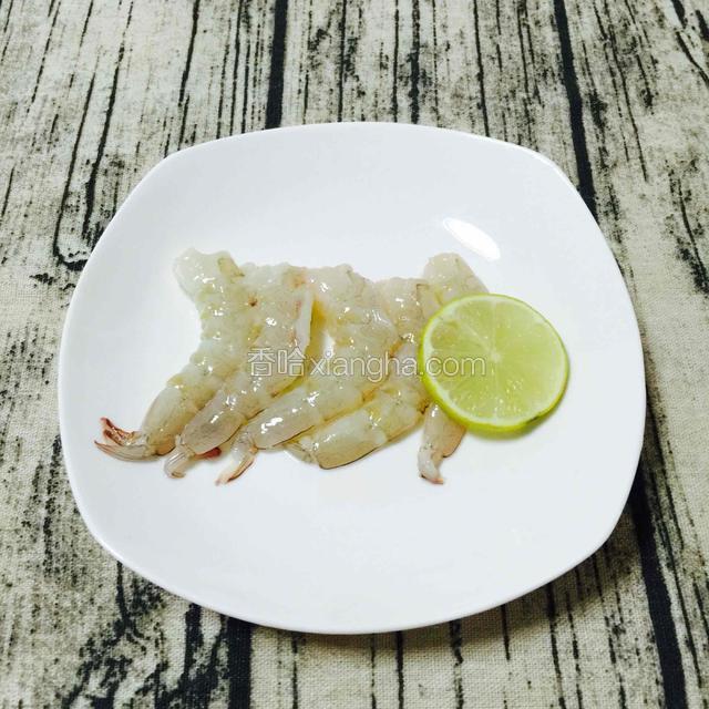 把虾去壳挑虾线，柠檬汁腌渍一下除腥味。这个虾是需要白灼煮熟的。
PS：海鲜类，用柠檬汁很除腥，味道也更好。