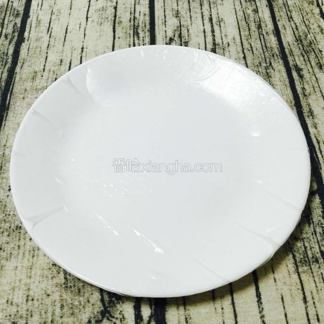 准备一干净盘子，把浸泡好的米皮平摊在盘子上。