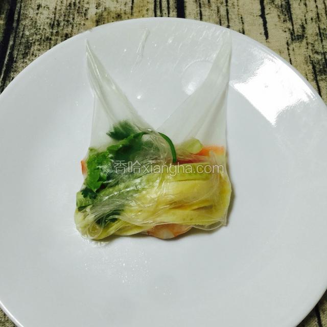 把米皮向上卷起，再左右收边，再往上一卷，底层的虾就翻面过来，再卷住，卷成一个春卷形状即可。
过程要小心轻放，不然米皮会容易裂开。