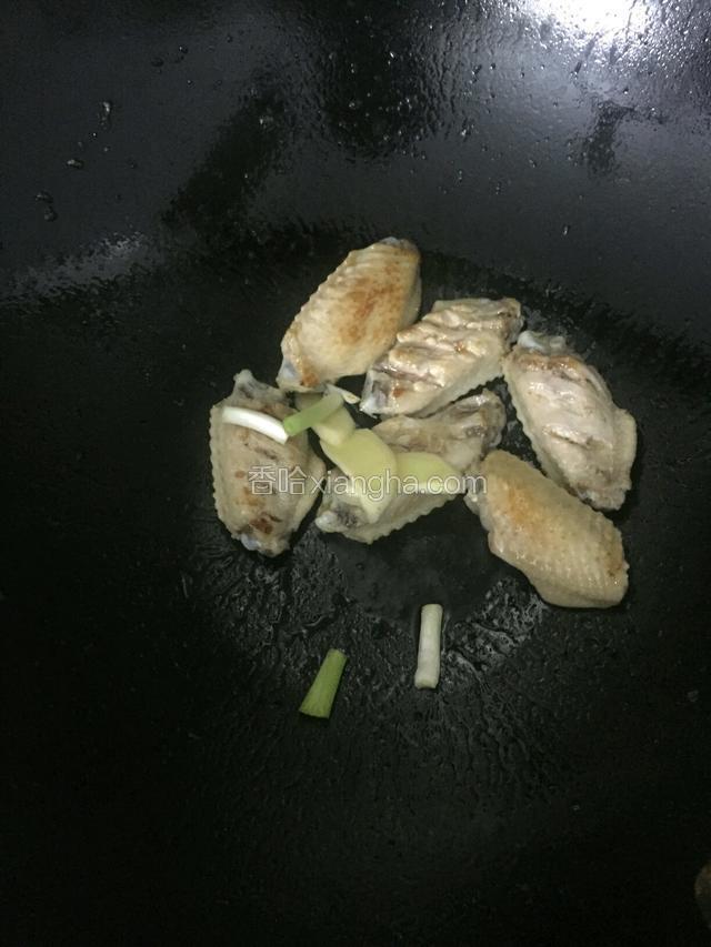 锅下油，下姜下葱条和鸡翅翻炒2分钟。