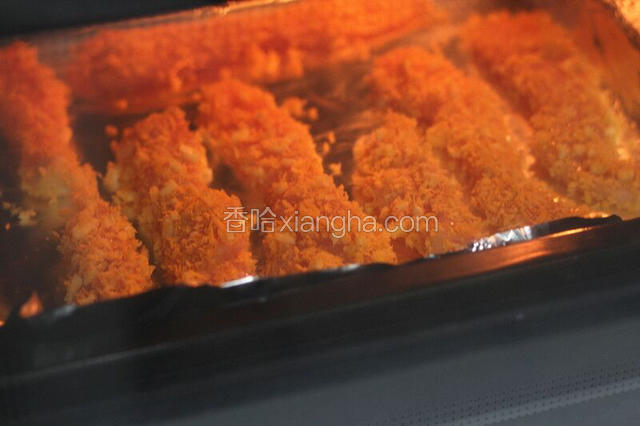 鸡柳都裹好面包糠后，铺上已经铺好锡纸的烤盘里，这时可以放入烤箱烤制啦！