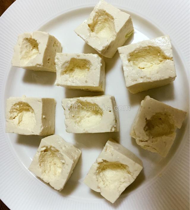 豆腐控水用纸巾擦干，然后每块豆腐上都挖个小穴。