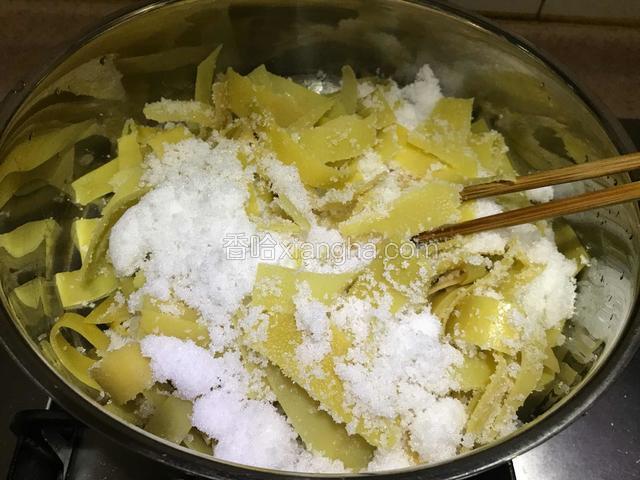 取不锈钢平底锅，将柚子皮和糖拌入。开小火慢慢炒。