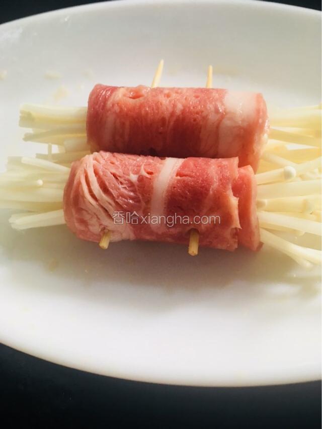 向上卷起，用同样的方法再卷一个，两个放在一起，在培根的接口处用牙签穿透固定如图所示。