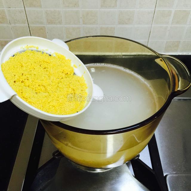 大米煲煮半个钟后，
接着再加进小米一起煲煮，
途中搅拌一下，免得粘锅。
