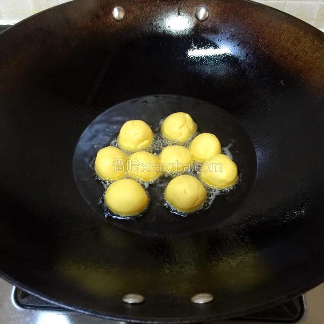 开中小火，热锅，倒进适量烹饪橄榄油。烧至4~5分热，调小火，放进南瓜球煎炸。

