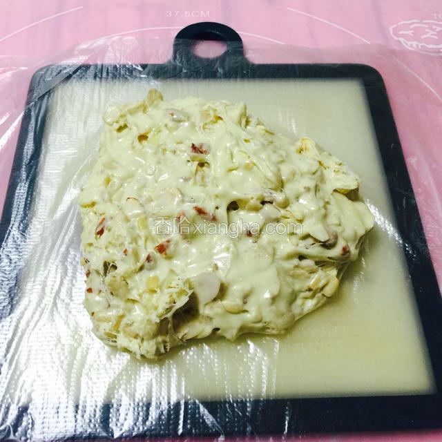 倒到提前铺好保鲜膜的砧板上。
用保鲜膜才不会粘。