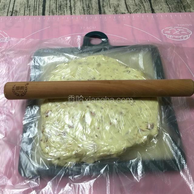 趁糖热、软，塑型。
如果有牛轧糖模具方便些。没有也没关系，如下操作：
再盖上一张保鲜膜，用擀面杖擀成合适的厚度，大约1~1.5cm，再用陶瓷刀修齐边缘。