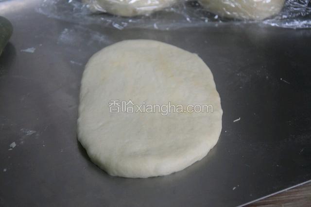 用擀面杖擀成椭圆形，再从上往下卷起来