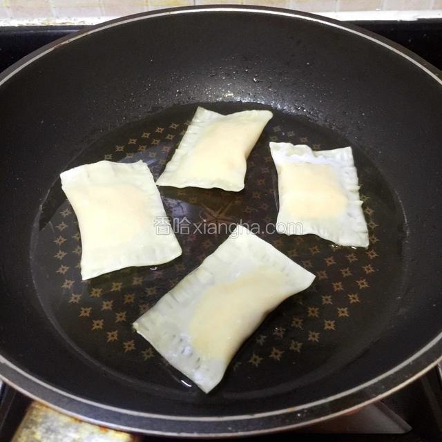 把榴莲派放进平底锅，开中火。
不能小火，饺子皮起不了酥脆，大火容易烧焦，中火适宜。