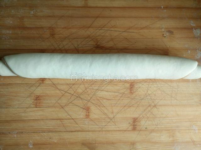 把俩个面团擀成饼，白色面饼抹上水，再把红色面饼放在上边卷起来