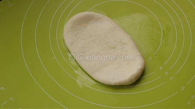 取一块松弛好的面团，按扁，擀开