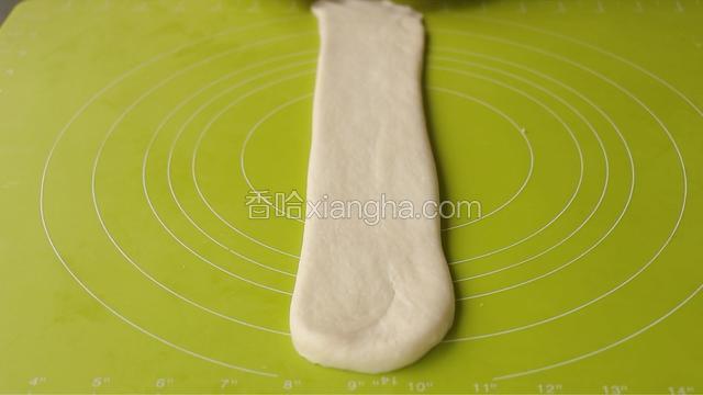 取一块松弛好的，收口朝上，擀长，压薄底边