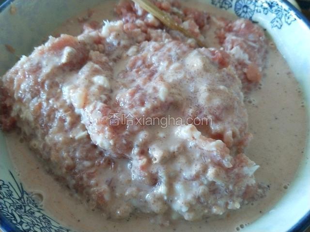 拌好的调料糊倒入肉内，顺时针搅打均匀上劲