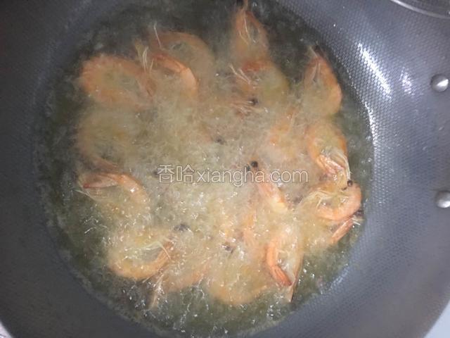 接下来锅中放入油烧至七成热倒入大虾炸至金黄捞出沥干油份……