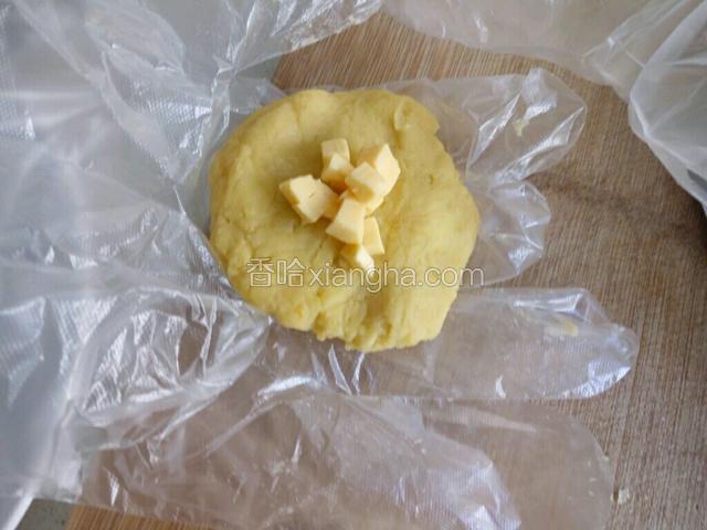 取一勺红薯泥，轻轻压成片状，包入芝士丁。