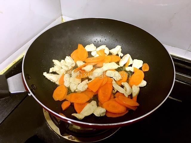 倒入胡萝卜片翻炒均匀。