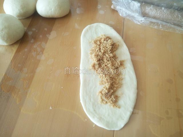 一份白色的面团 加入肉松 也一样从一侧卷起 