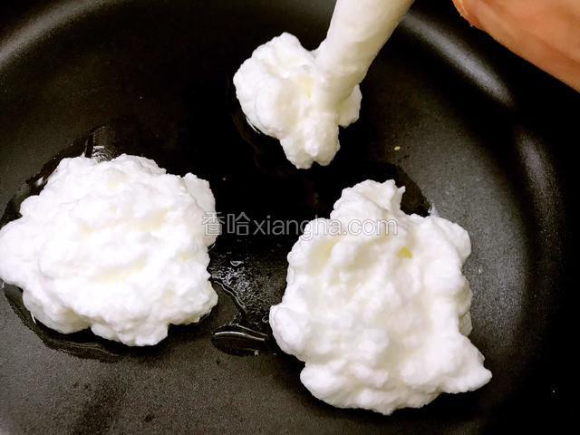 将裱花袋里的蛋白挤在平底锅内的油上