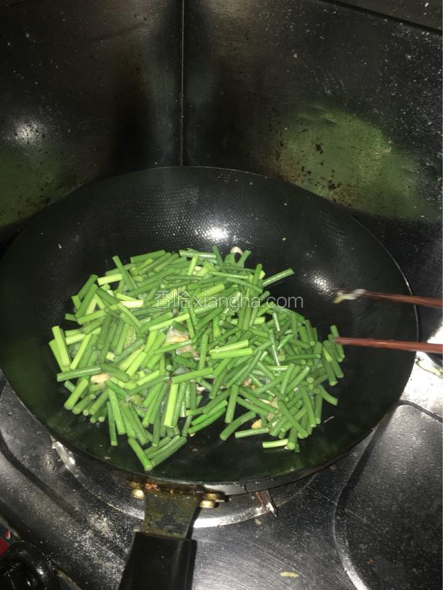 翻炒出香味，放入蒜苔中火，爆炒。