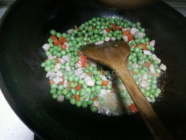 另起锅放油，倒入豌豆翻炒，然后倒入肉丁、红椒丁炒熟加入盐、鸡精、白糖炒均捞出。