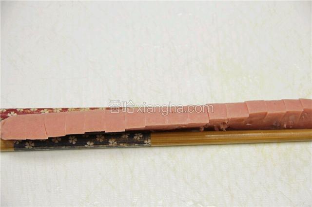 用筷子固定火腿肠切段，但不能切断。