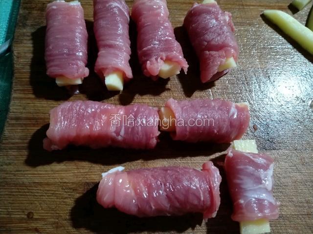 土豆和里脊肉切好就开始卷了，里脊肉放平放入土豆条从尾部一直卷，如图所示，把接口朝下放置
