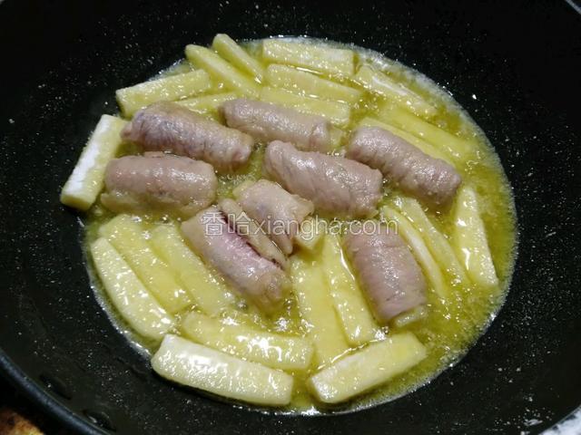 煎炸至一分钟左右可以晃动锅中的里脊肉再放入剩下的土豆条一起煎炸至金黄色即可