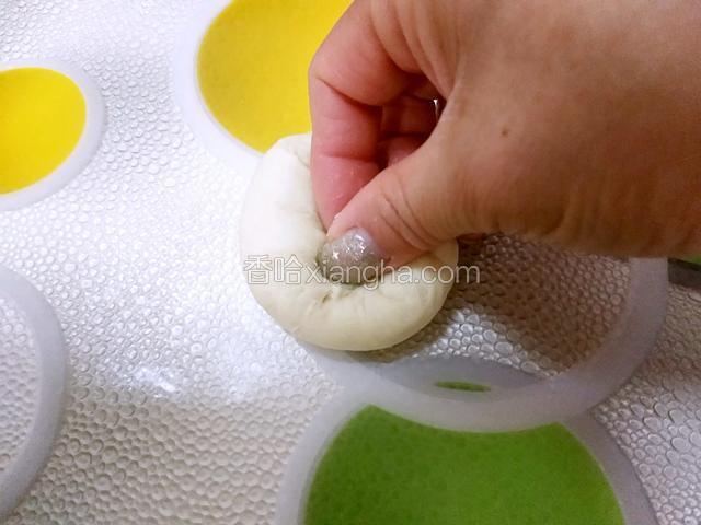取一个面团用手指往中间按压，揉几下即可