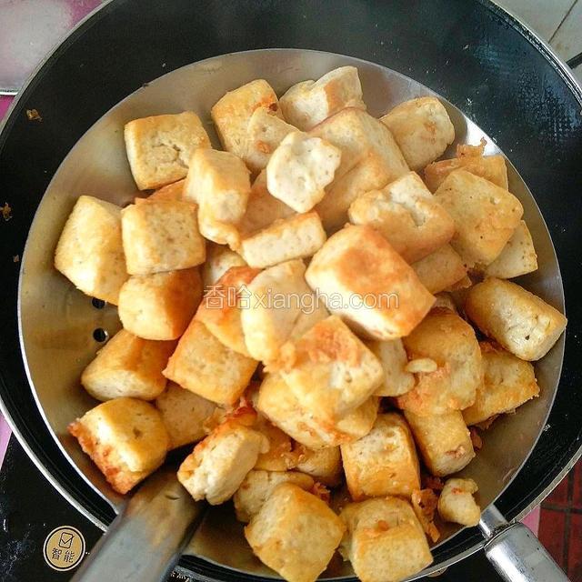 锅内加入食用油，下豆腐炸至金黄，捞出待用。