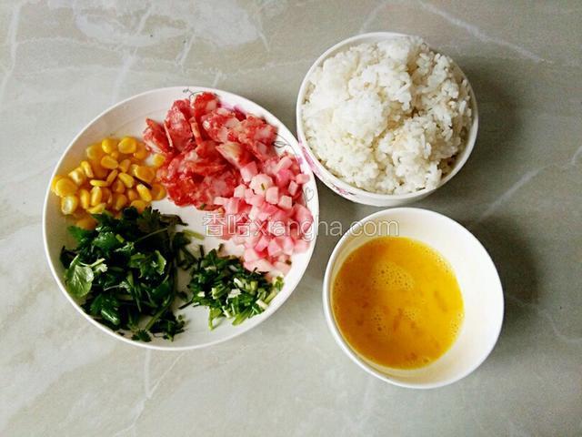 准备以下材料：腊肠、酸萝卜、香菜、葱花切好备用、玉米粒煮熟、鸡蛋打散、米饭