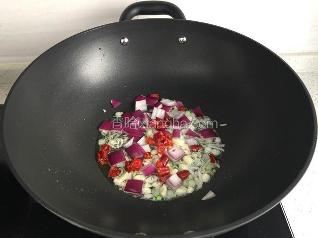 锅倒油烧热放葱花，蒜粒，紫洋葱丁，干树椒段炒香。