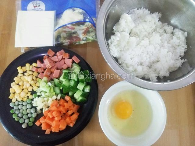 首先准备好全部食材 
米饭是前一天的剩饭 而且要硬一点的才好  用筷子播散备用 黄瓜 胡萝卜洗净切丁 儿童香肠切丁 葱蒜切末 玉米粒和青豆都是买的现成的速冻食品 鸡蛋打好备用 奶酪准备了奶酪片和马苏两种