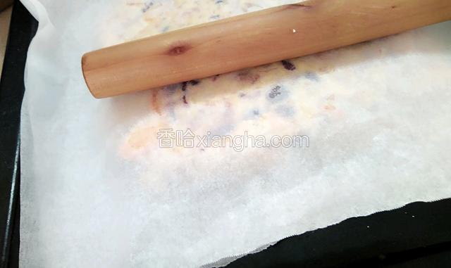 再盖上油纸用擀面棍压实擀平