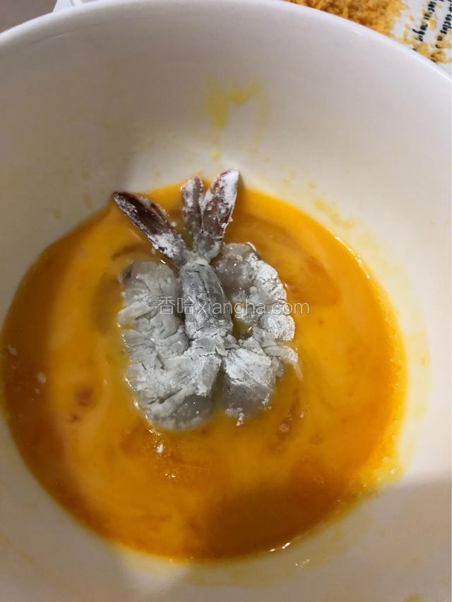 在蛋液中加入少量的盐和五香粉。
把虾放进去，均匀裹上蛋液。