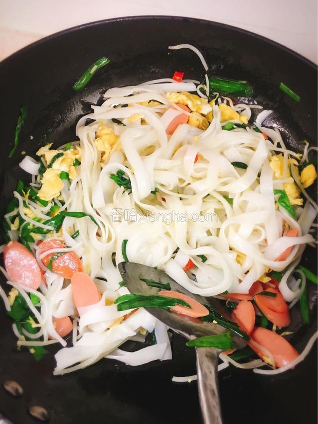 将宽米粉倒入锅中，加入味极鲜酱油、老抽，翻炒上色.