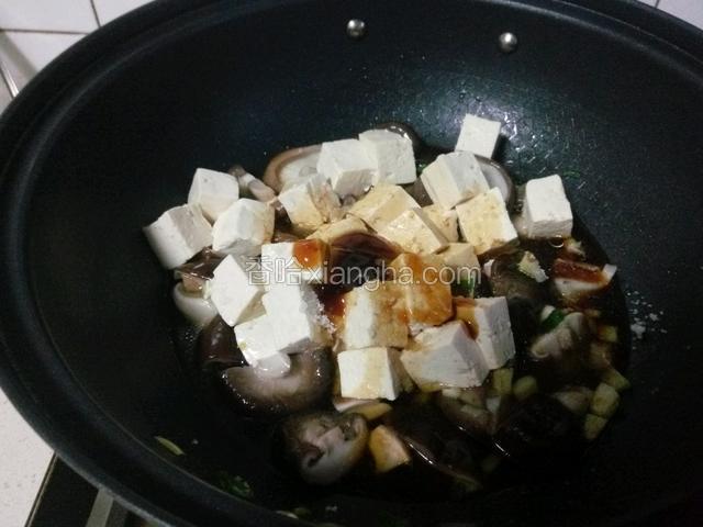 下入豆腐，加酱油、糖、盐、蚝油、胡椒粉调味，加热水稍煮一会。豆腐易碎，要轻轻推动，不要翻炒。