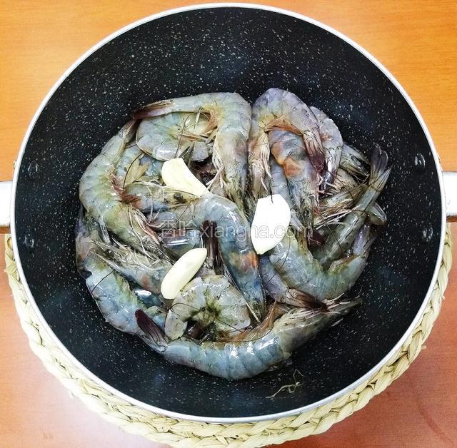 去完虾线，一瓣蒜切片和料酒一起倒入虾里面，腌制十分钟去腥。
