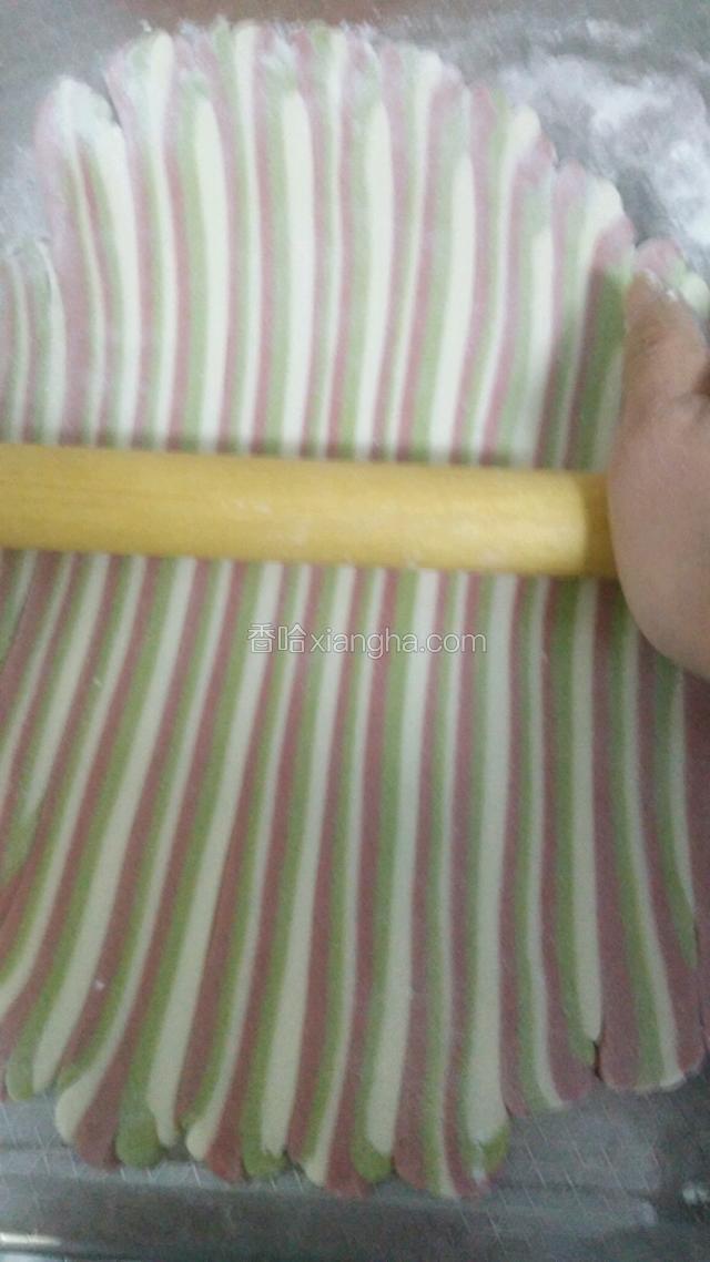 排沾好后在向长的方向擀长，上面擦水，横着卷好，然后稍微搓长一点